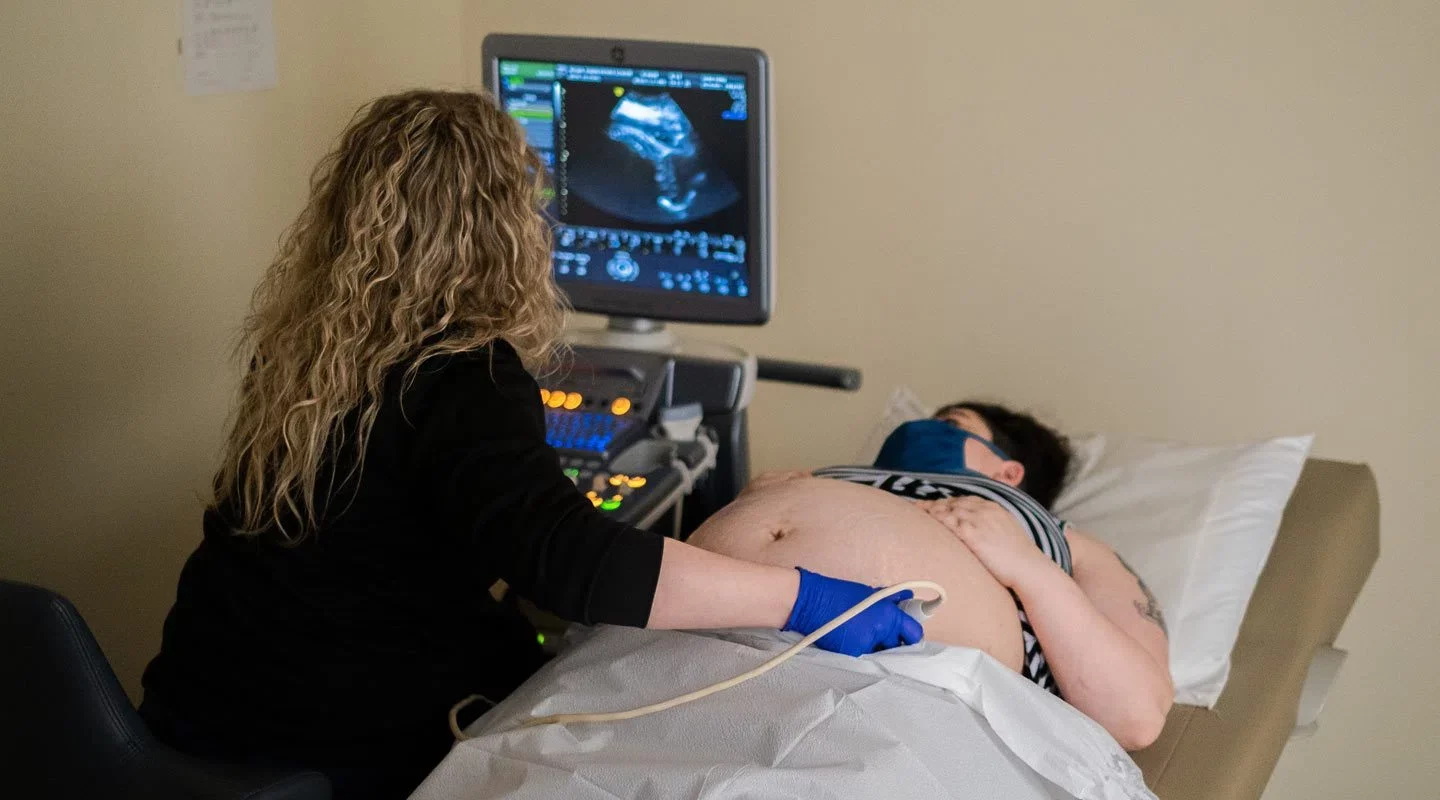 Photo of pregnant woman receiving an ultrasound from healthcare worker